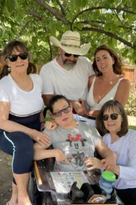 Family is gathered under a tree.